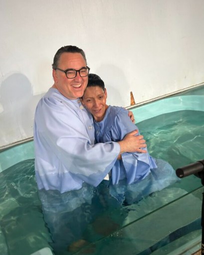 The pastor hugging a newly baptized member